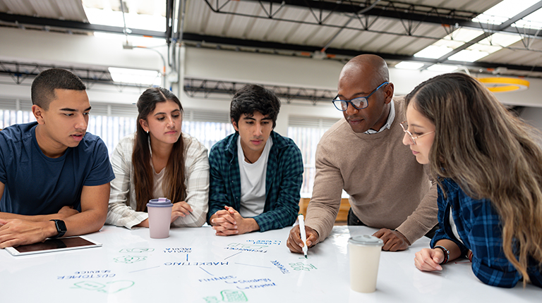 Teacher tutoring a group of college students